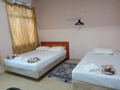 2 camas sentadas en una habitación sin ascensor en Hotel Ikhwan Tanjung Malim, en Tanjung Malim