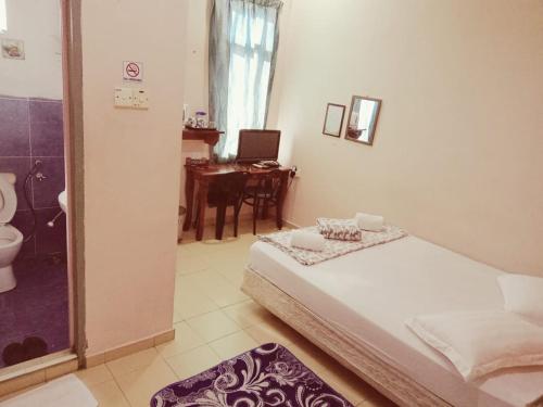 1 dormitorio con 1 cama y baño con escritorio. en Hotel Ikhwan Tanjung Malim, en Tanjung Malim