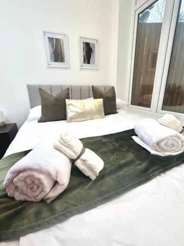 1 dormitorio con 2 toallas en una cama en London Charm - Stylish Room in Spacious Home en Londres