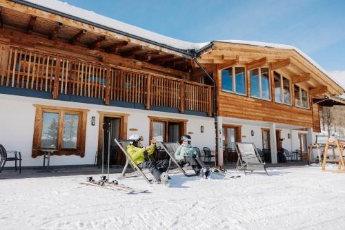 two people on skis in front of a building at Thurntaler Rast in Außervillgraten