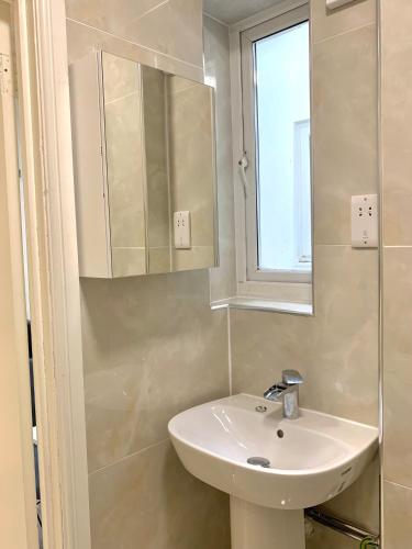 bagno con lavandino e specchio di London Charm - Stylish Studio in Kensington a Londra