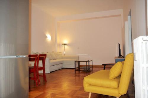 salon z żółtym krzesłem i kanapą w obiekcie Splendido appartamento a Pagano w Mediolanie