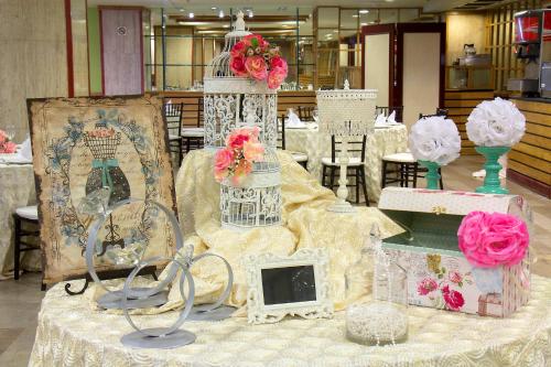 a table with flowers and vases on top of it at Travohotel Monterrey Histórico in Monterrey