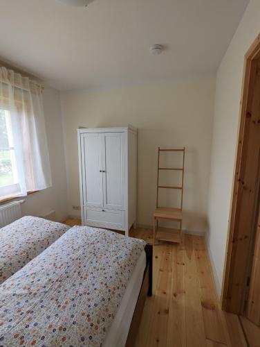 um quarto com uma cama e um armário branco em Ferienwohnung Wittenförden em Wittenförden