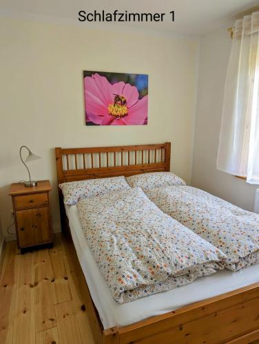 uma cama num quarto com uma flor rosa na parede em Ferienwohnung Wittenförden em Wittenförden