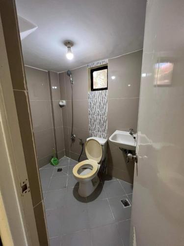 a bathroom with a toilet and a sink at Jimsville executive homes in Liloan