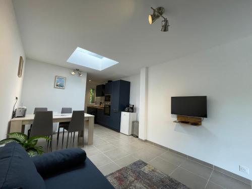 un salon avec un canapé et une télévision sur un mur dans l'établissement Appartement Étables-Sur-Mer à 10 minutes à pied de la mer, en plein centre-ville, à Étables