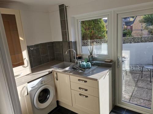 a kitchen with a sink and a washing machine at Hopefield in Newport