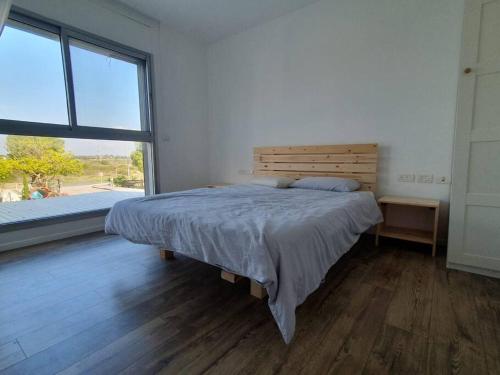 a bedroom with a bed and a large window at Golden beach cottage by the sea in Caesarea