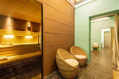 a bathroom with two wicker chairs and a mirror at LA MAISON DU CHATEAU in Bélesta