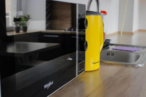 a yellow juicer sitting next to a microwave at Hostel on Universytet in Kyiv
