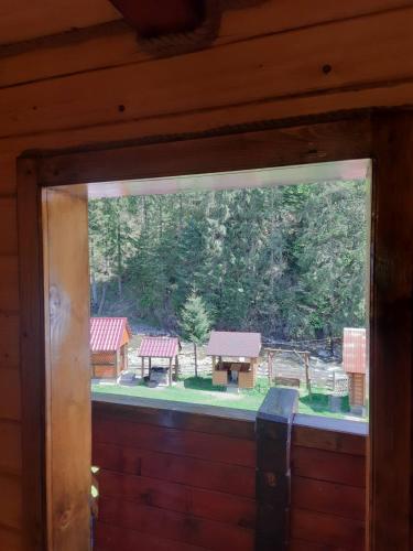 a window in a cabin with a view of a park at Крайня Хата in Synevyrsʼka Polyana