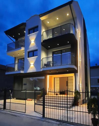 a large white building with a fence in front of it at Apartments Mite in Ohrid