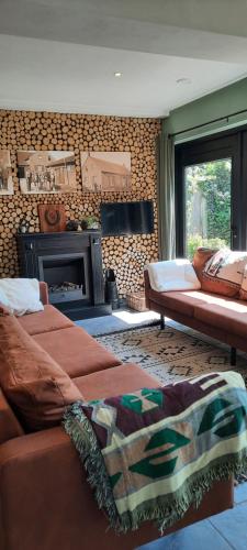 ein Wohnzimmer mit 2 Sofas und einem Kamin in der Unterkunft vakantieboerderij Aardenhof in Sevenum