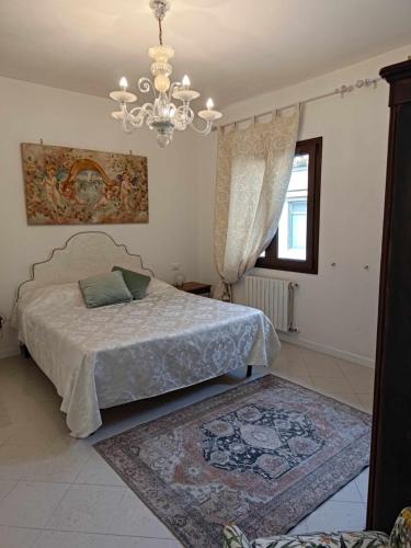 um quarto com uma cama e um lustre em Bertos house tra mare e laguna em Cavallino-Treporti