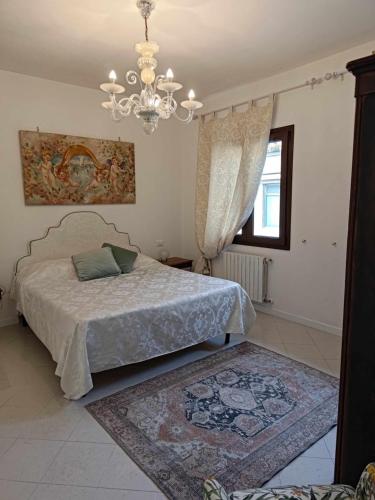 a bedroom with a bed and a chandelier at Bertos house tra mare e laguna in Cavallino-Treporti