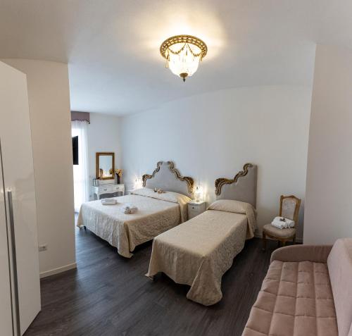 a bedroom with two beds and a chandelier at Sinfonia 23 in Ravenna