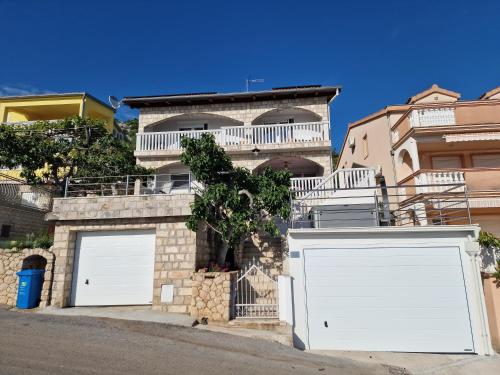a house with two white garage doors in front of it at Apartman Bella in Drage