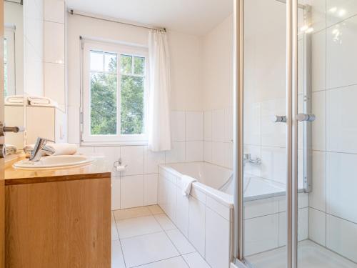 een witte badkamer met een douche en een wastafel bij Grüne Straße FeWo G4 (DG rechts) in Prerow