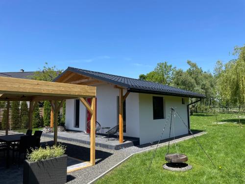 a tiny house with a porch and a swing at RedDoor Zator Lake Houses in Zator