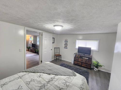 een slaapkamer met een bed en een televisie. bij Couples lake house retreat. in Dayton