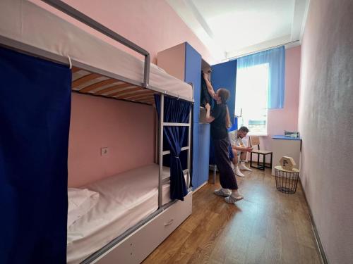 two people standing in a dorm room with bunk beds at Hostel on Universytet in Kyiv