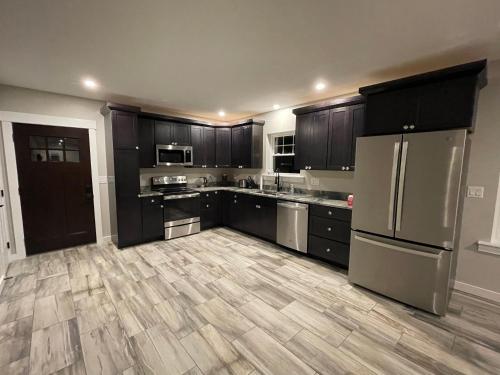 a kitchen with black cabinets and a wooden floor at New ranch on RIVER with spectacular views in Brewer