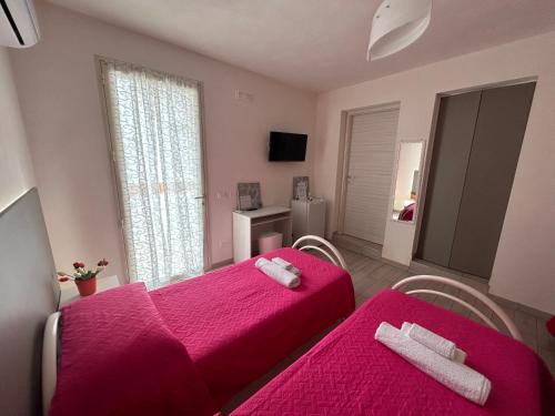 sala de estar con 2 camas y manta rosa en B & B Da Rosa, en Petrosino