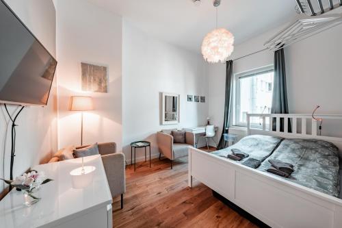 a white bedroom with a bed and a living room at homestay! einhundertachtunddreißig in Bremen