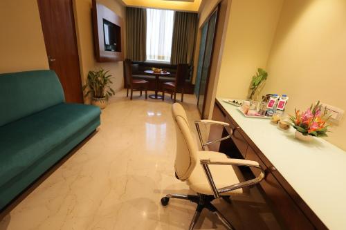 Una televisión o centro de entretenimiento en Regenta Orkos Kolkata by Royal Orchid Hotels Limited