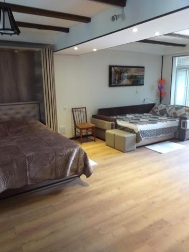 Un dormitorio con 2 camas y una silla. en APARTMENT B O R A en Tskaltubo