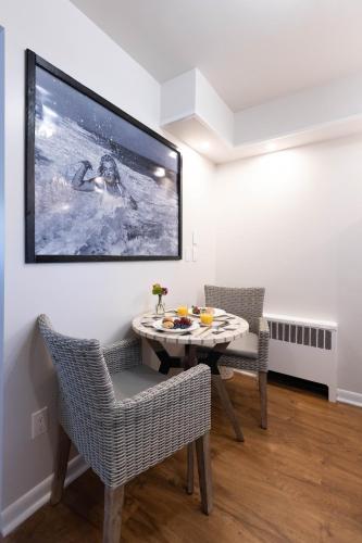 a dining room with a table and chairs and a tv at Ocean View Terrace in Hampton Bays