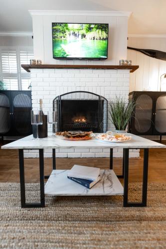 a living room with a fireplace and a table with a pizza at Ocean View Terrace in Hampton Bays