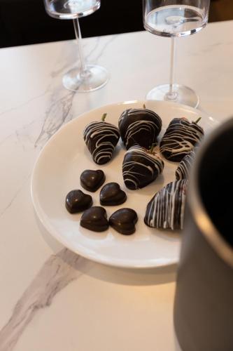a plate of chocolate covered cookies and wine glasses at Ocean View Terrace in Hampton Bays