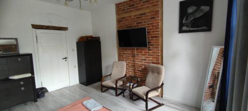 a living room with chairs and a brick wall at LIBERation! in Olsztyn