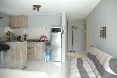 a kitchen with a refrigerator and a couch in a room at Captain's Quarters Studio in Palmyre