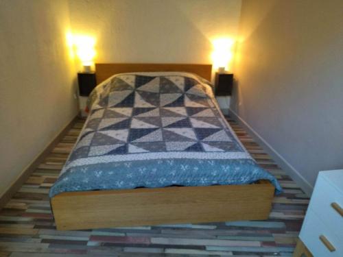uma pequena cama num quarto com duas luzes em SUD ET DETENTE em Gallargues-Le-Montueux