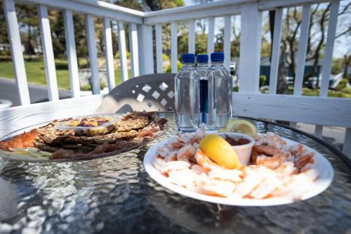 a table with a plate of food and a bottle of water at Ocean View Terrace in Hampton Bays