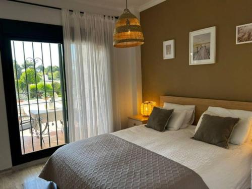- une chambre avec un lit et une grande fenêtre dans l'établissement Ruim appartement, zonnig terras, Alhaurin Golf!, à Alhaurín el Grande