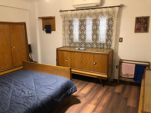 ein Schlafzimmer mit einem Bett, einer Kommode und einem Fenster in der Unterkunft Luxury three bedroom apartment in degla maadi in Kairo