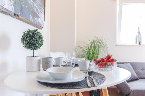 a white dining room table with a bowl of fruit on it at 4 You Apartments in Mugeba