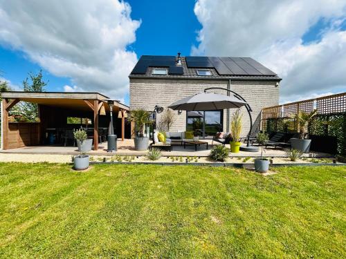 Cette maison dispose d'une terrasse avec un parasol. dans l'établissement L'échappée Belle by J&J Durbuy Area, à Clavier