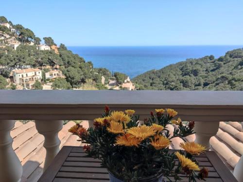 un vase de fleurs assis sur un balcon donnant sur l'océan dans l'établissement Magnifique villa vue mer, à Begur