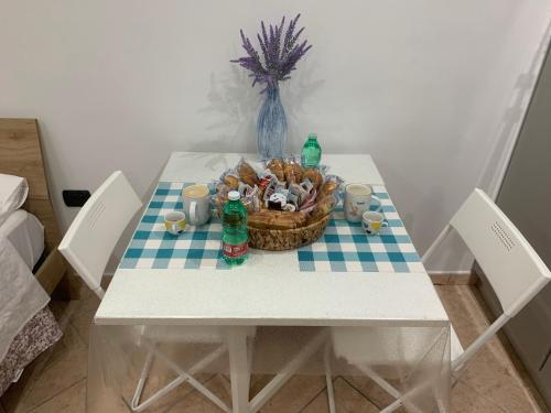 een tafel met een mand met eten en flessen erop bij San Ciro's apartment in Portici