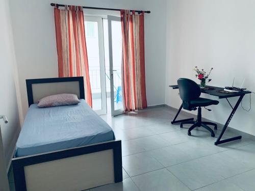 a bedroom with a bed and a desk and a chair at Apartment in Gramsh