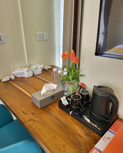 a wooden table with a stove and flowers on it at Romano Hotel in Kampot