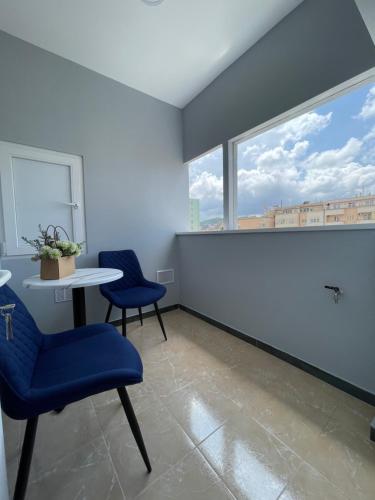 um quarto com duas cadeiras, uma mesa e uma janela em Voyage Penthouse em Tirana