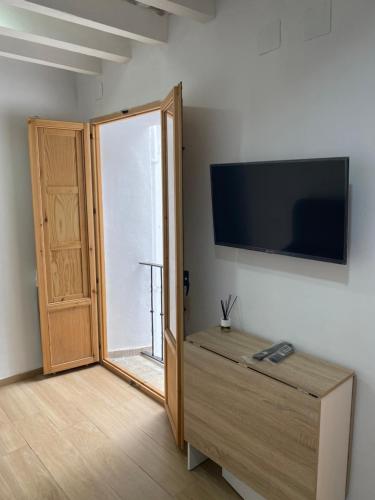 ein Zimmer mit einer Tür und einem Fernseher an der Wand in der Unterkunft EL VENENCIADOR in Jerez de la Frontera