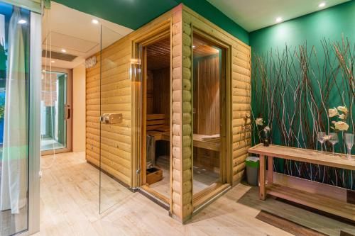 uma cabina de duche ao nível do chão numa casa de banho com paredes verdes em Joan Apartments & Spa em Skopje