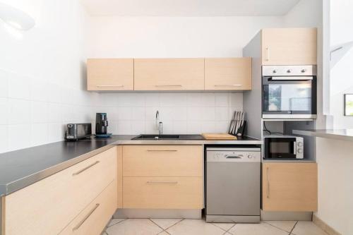 une cuisine avec des armoires en bois et des appareils en acier inoxydable dans l'établissement Just in Cap Canaille, à Cassis